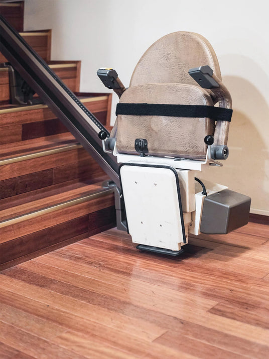 Seated stairlift in use on a staircase.